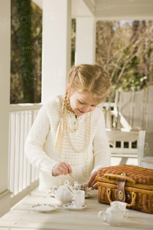 Girl having tea party on porch. Date : 2008