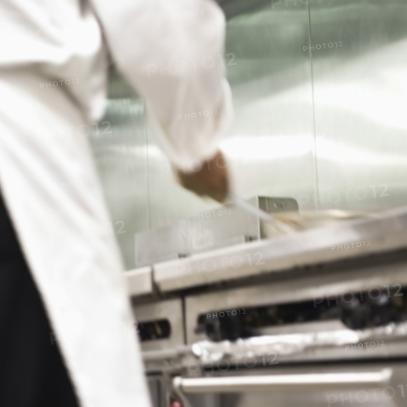 Chef shaking pan on stove. Date : 2008
