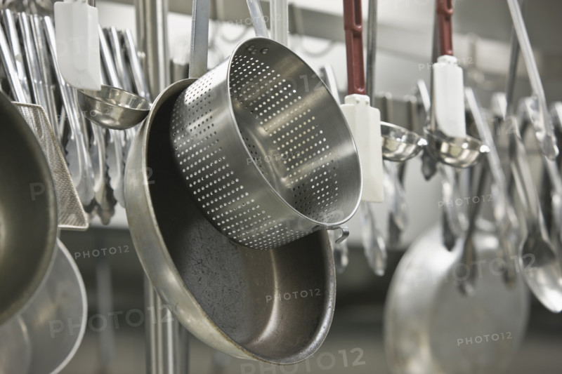 Pots and cooking utensils hanging from rack. Date : 2008
