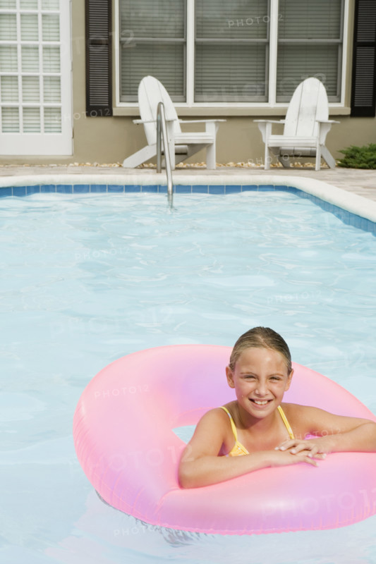 Girl floating on inflatable ring in swimming pool. Date : 2008