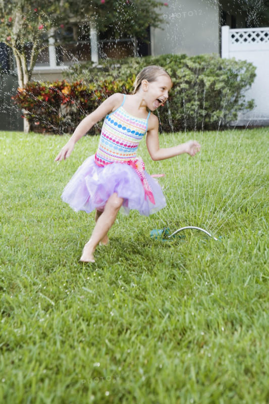 Girl running through sprinkler. Date : 2008