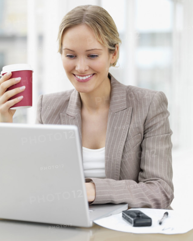 Businesswoman working on laptop at cafe. Date : 2008