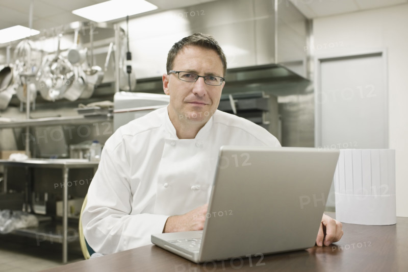 Chef working on laptop in kitchen. Date : 2008