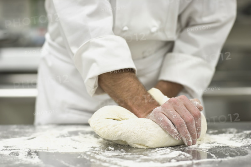 Baker kneading bread dough. Date : 2008