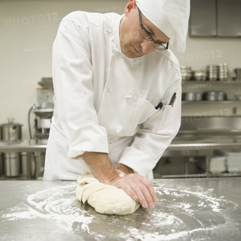 Baker kneading bread dough. Date : 2008