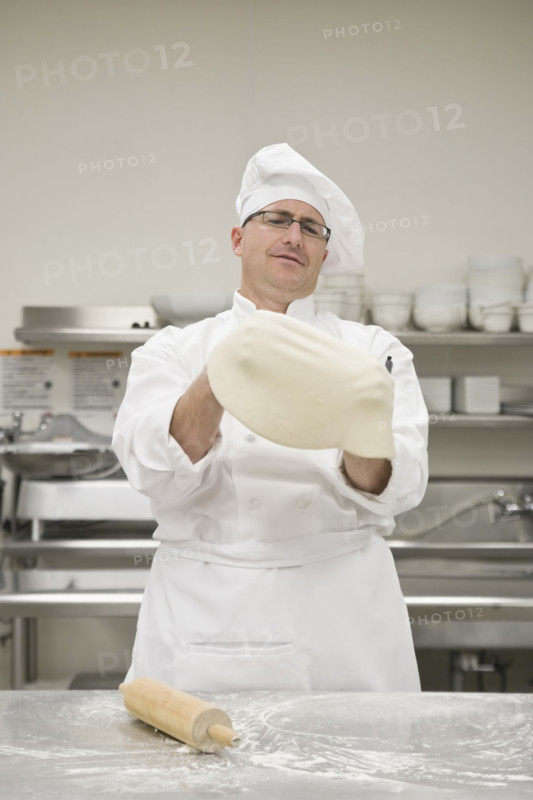 Chef stretching pizza dough. Date : 2008