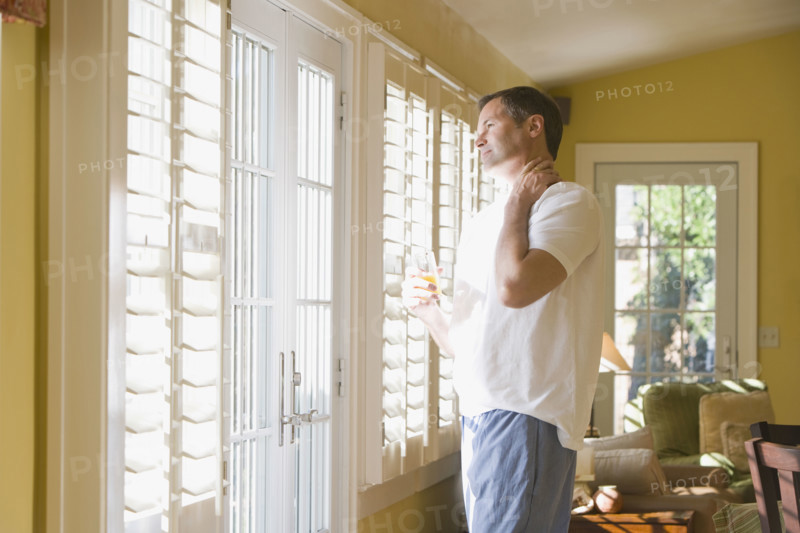 Man in pajamas looking out window. Date : 2008