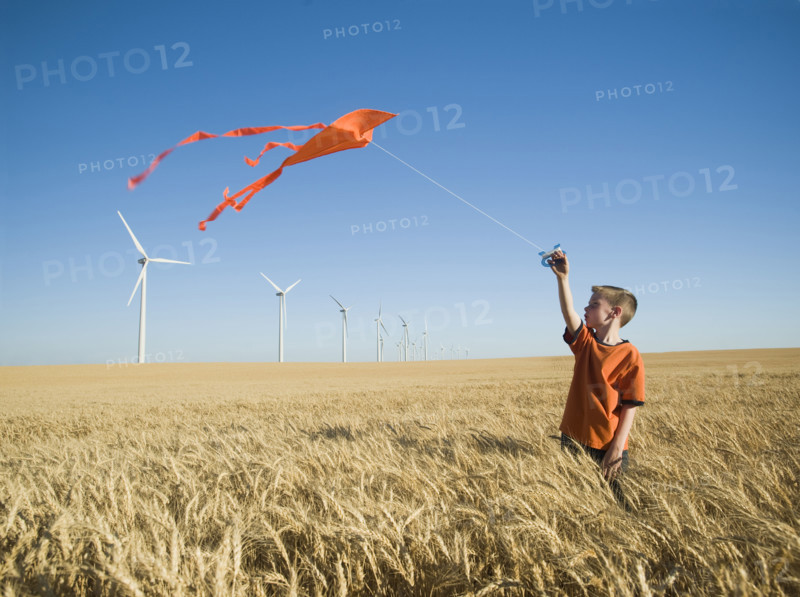 Boy running with kite on wind farm. Date : 2008