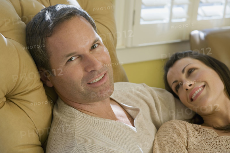 Couple relaxing in livingroom. Date : 2008