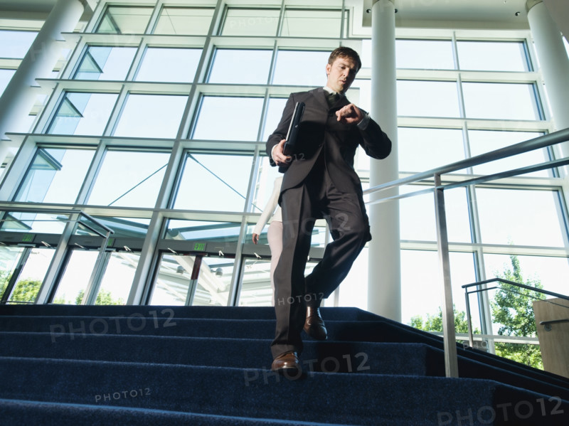 Businessman descending office building stairs. Date : 2008