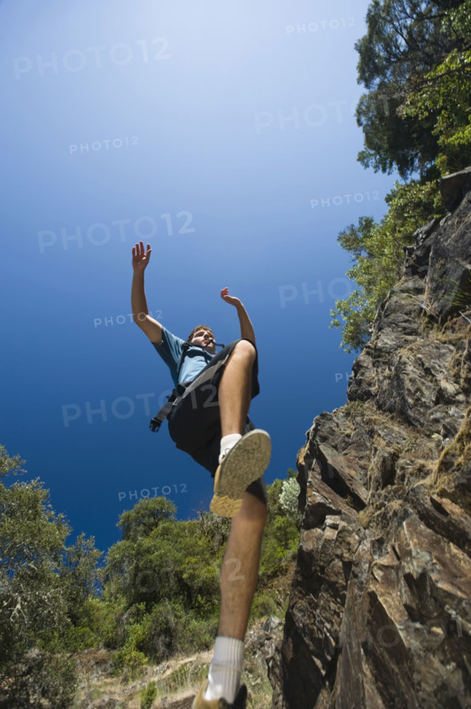 Hiker jumping down rocky trail. Date : 2008