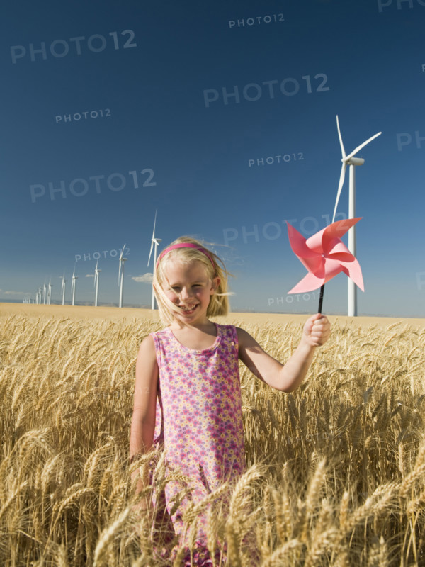 Girl holding pinwheel on wind farm. Date : 2008