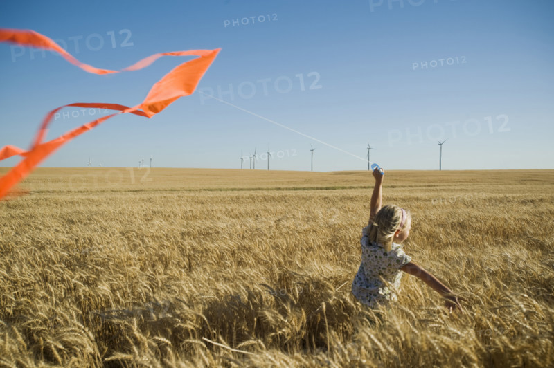 Girl running with kite on wind farm. Date : 2008