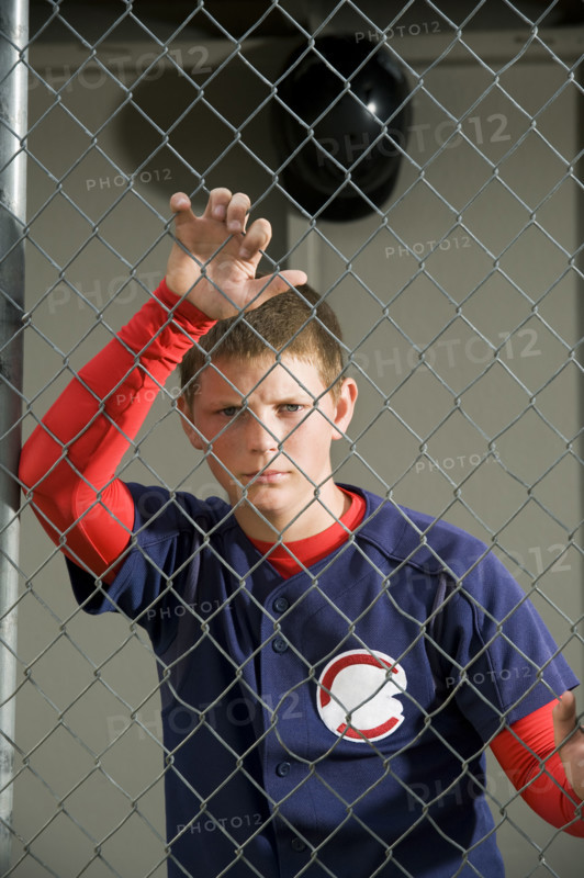 Serious baseball player standing in dugout. Date : 2008