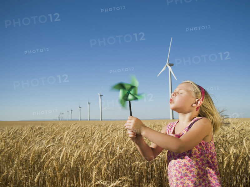 Girl holding pinwheel on wind farm. Date : 2008