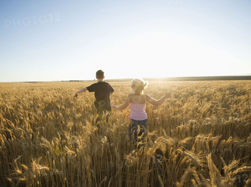 Children running through tall wheat field. Date : 2008