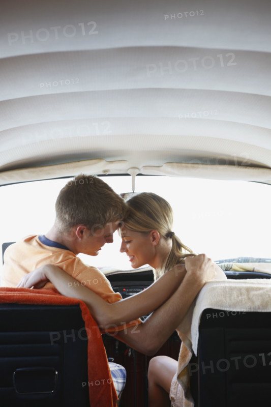 Young couple sitting in van on beach. Date : 2008