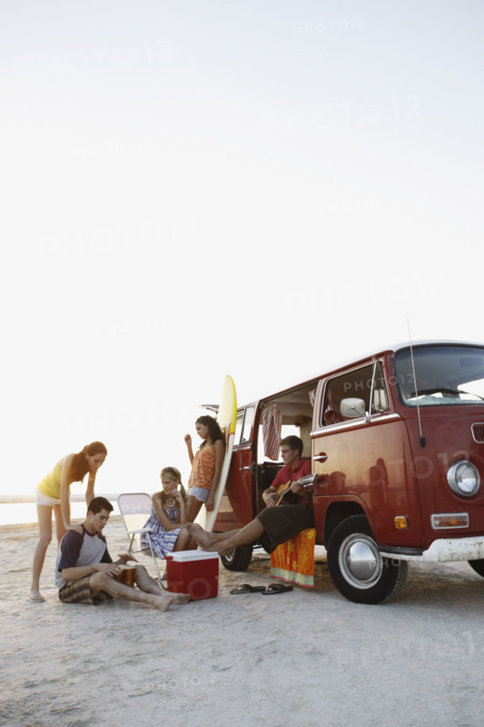 Friends socializing around van on beach. Date : 2008