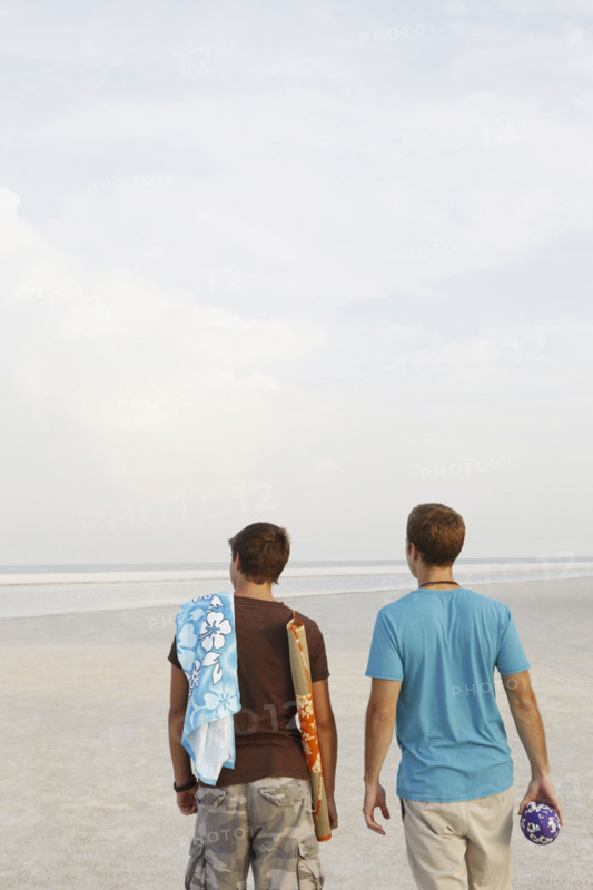 Young men walking on beach. Date : 2008