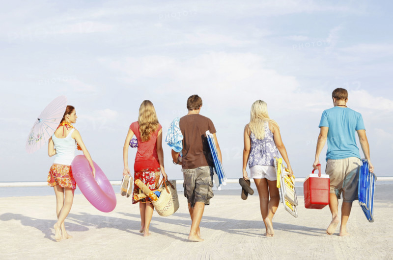 Friends walking with beach essentials. Date : 2008