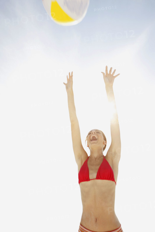 Young woman throwing beach ball in air. Date : 2008