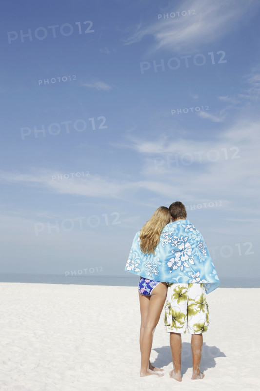 Teenage couple sharing towel on beach. Date : 2008