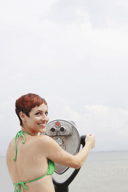 Woman looking through coin-operated binoculars. Date : 2008