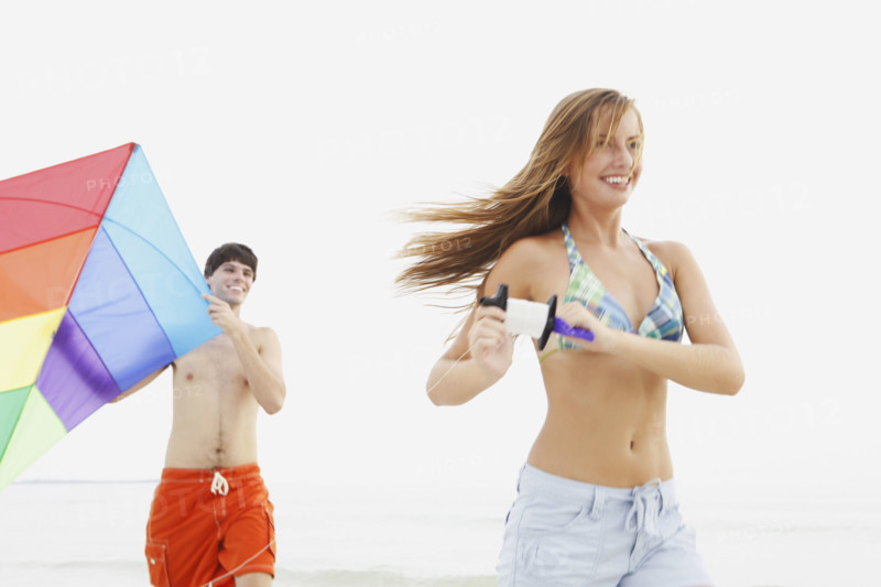 Friends flying kite on beach. Date : 2008
