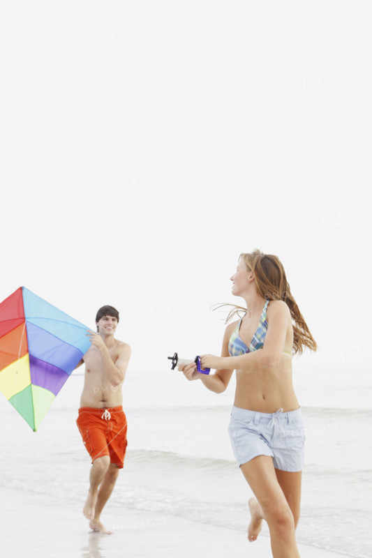 Friends flying kite on beach. Date : 2008