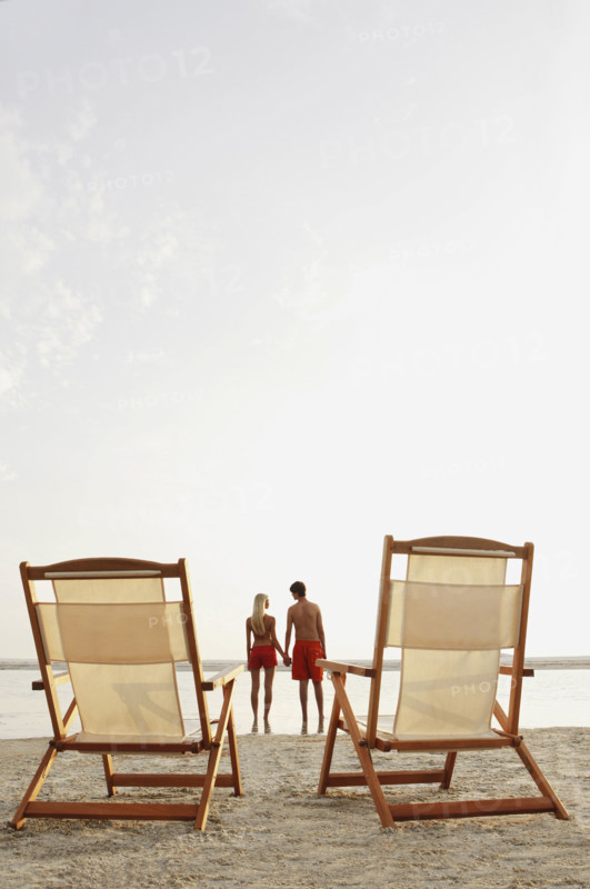 Young couple holding hands on beach. Date : 2008