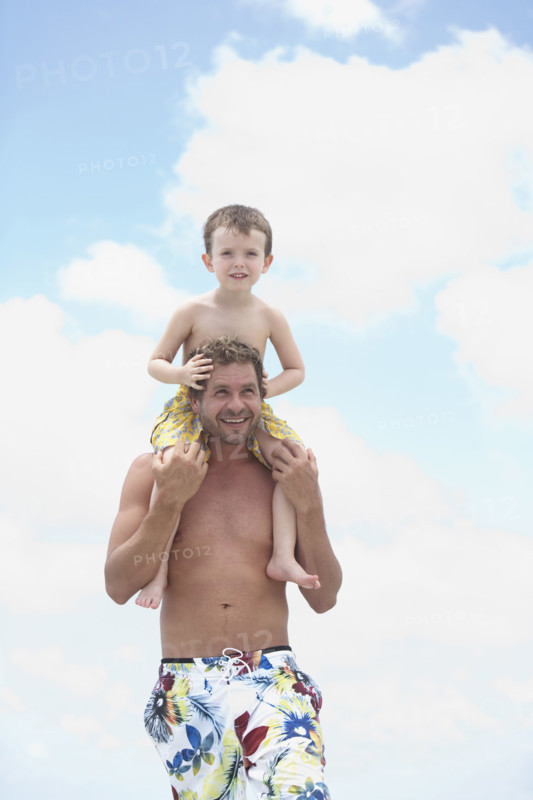 Father carrying son on shoulders. Date : 2008