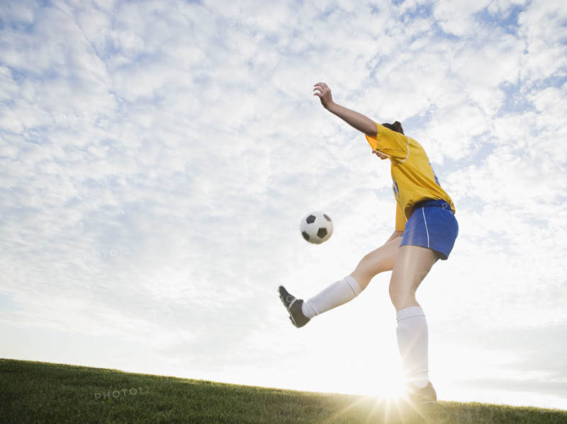 Teenage girl kicking soccer ball. Date : 2008