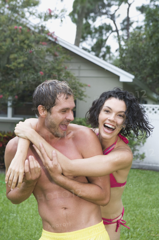 Couple in bathing suits hugging in backyard. Date : 2008