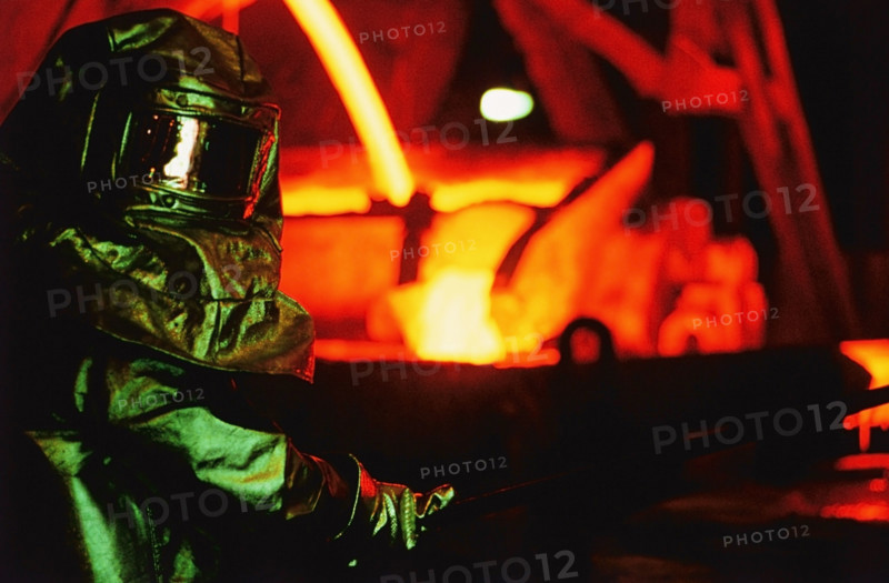 Worker in asbestos suit working in steel foundry. Date: 2008
