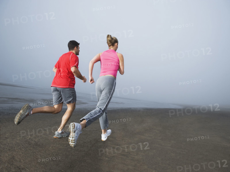 Couple jogging on foggy beach. Date : 2008
