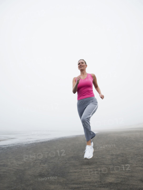 Woman jogging on foggy beach. Date: 2008