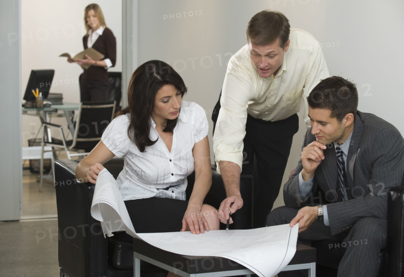 Business people examining blueprints.