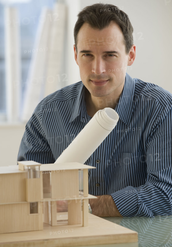 Portrait of architect with blueprints and building model.