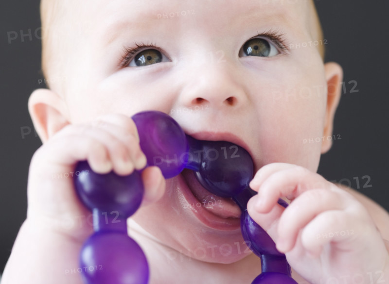Close up of baby gnawing on teething ring. Date : 2008