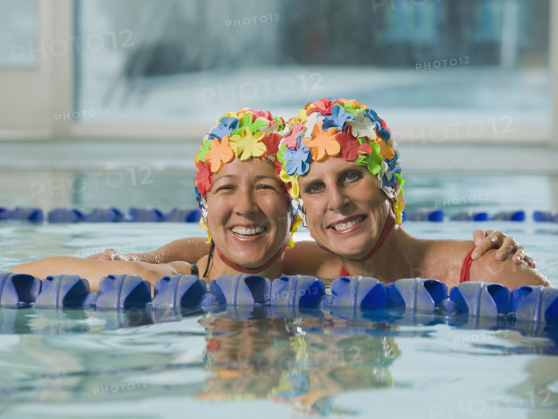 Women in swim caps hugging in swimming pool. Date : 2008