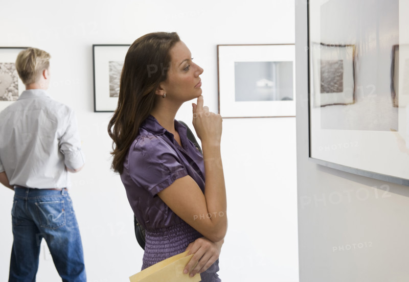 Woman looking at picture in art gallery.