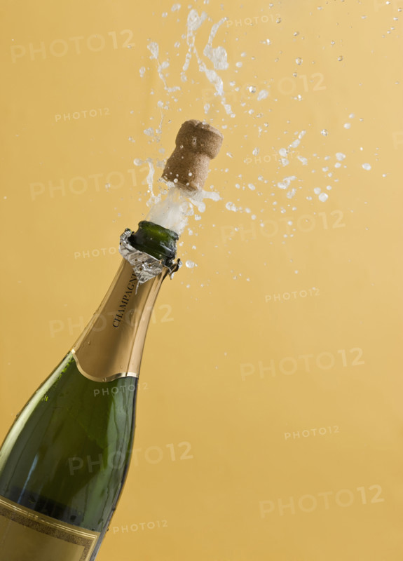 Cork exploding from champagne bottle.