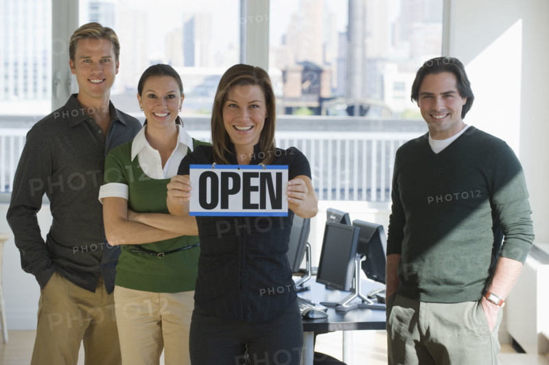 Portrait of business people holding ”Open” sign.