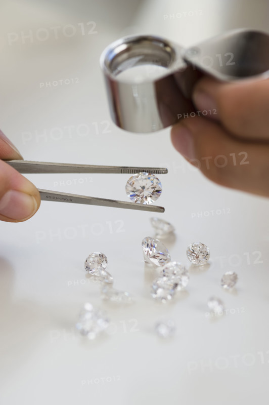 Gemologist inspecting diamonds using loupe.