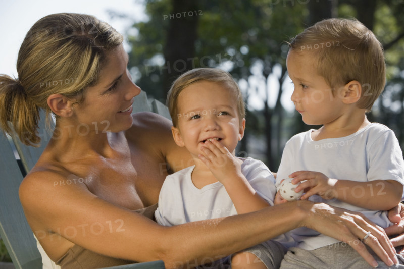 Mother holding twin toddler sons. Date : 2008
