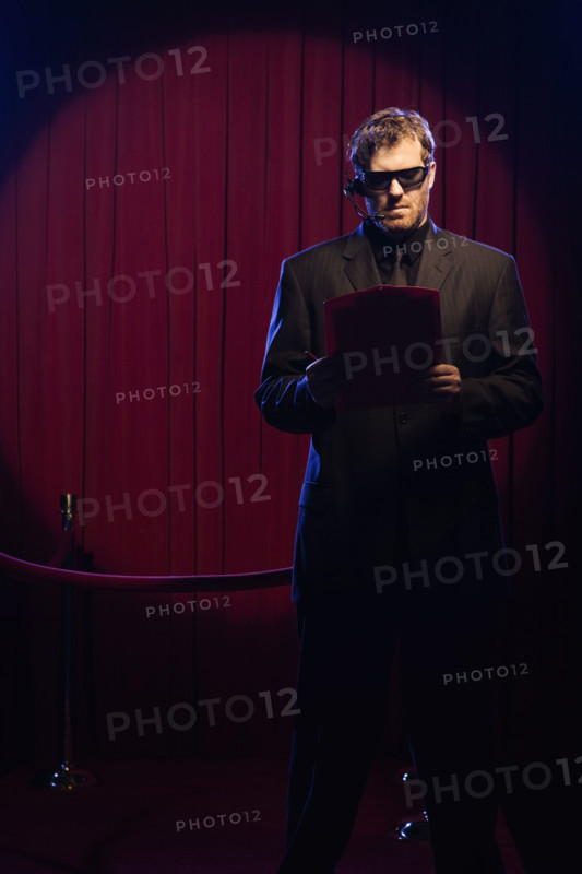 Bouncer looking at guest list. Date: 2008