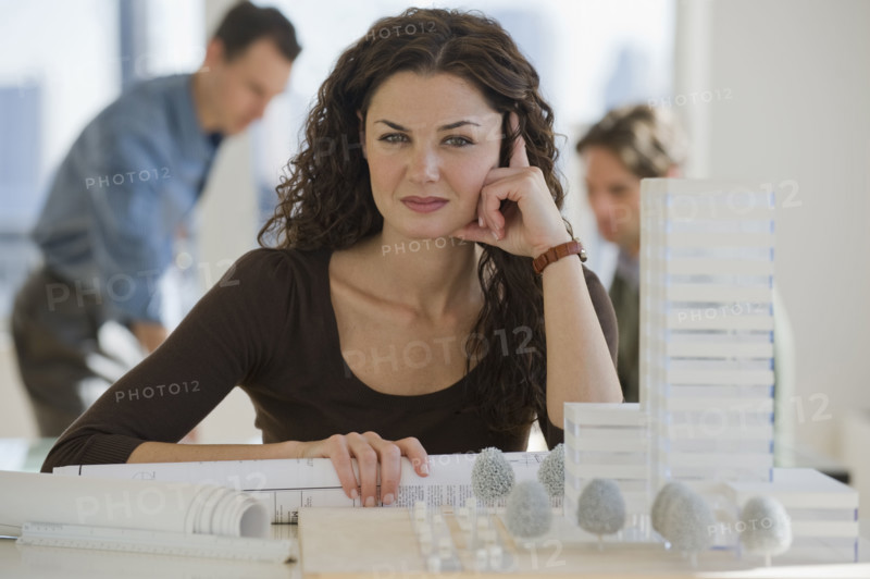 Portrait of architect with blueprints and building model.