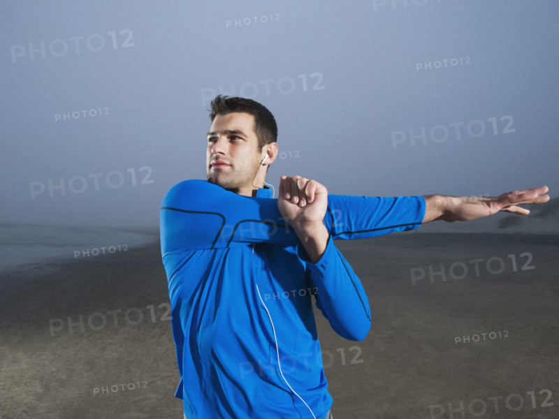 Man stretching on beach. Date : 2008
