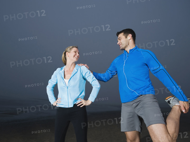 Couple stretching on beach. Date : 2008