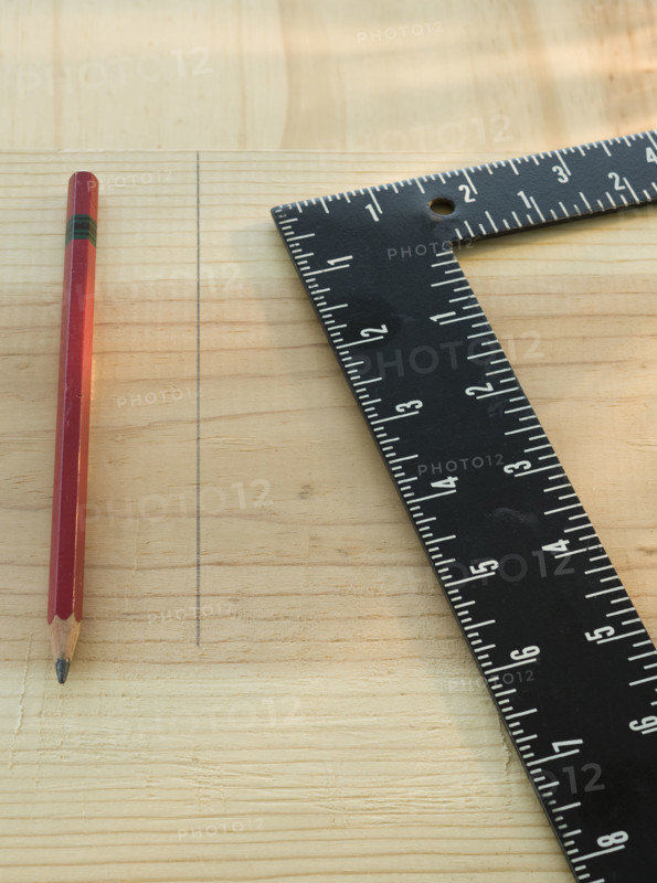 Pencil and carpenter’s rule on wood plank.